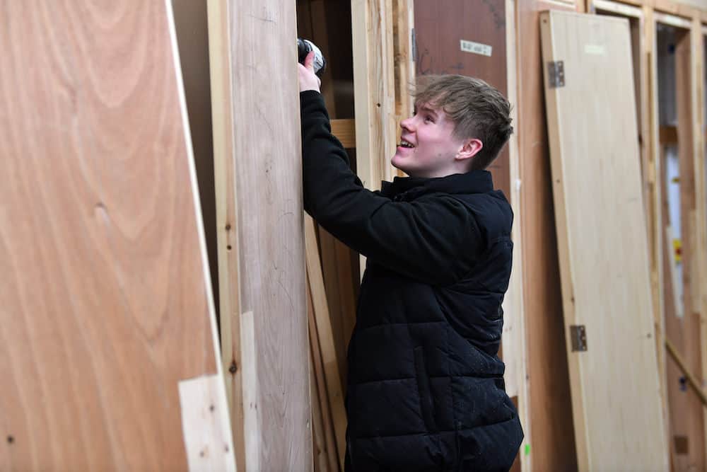 Learner using a drill on a door frame