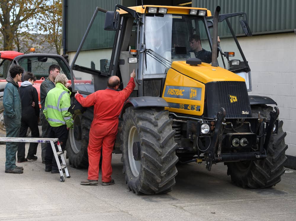 Learners working on a Yellow JCB tractor
